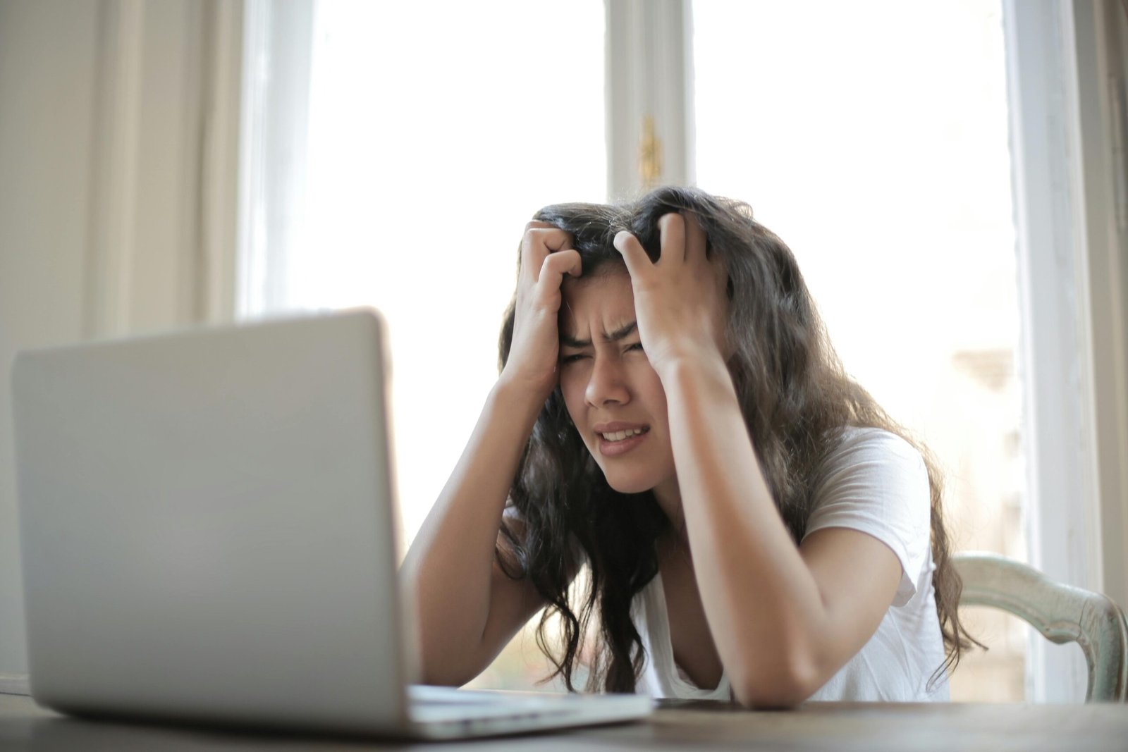 Woman in white shirt showing frustration after getting rejection on her visa application