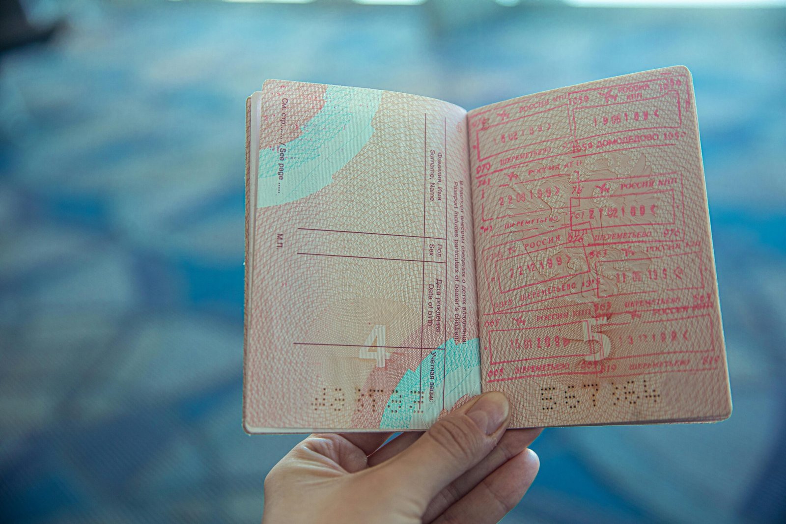 A traveller holding an opened passport with a Schengen visa sticker on it