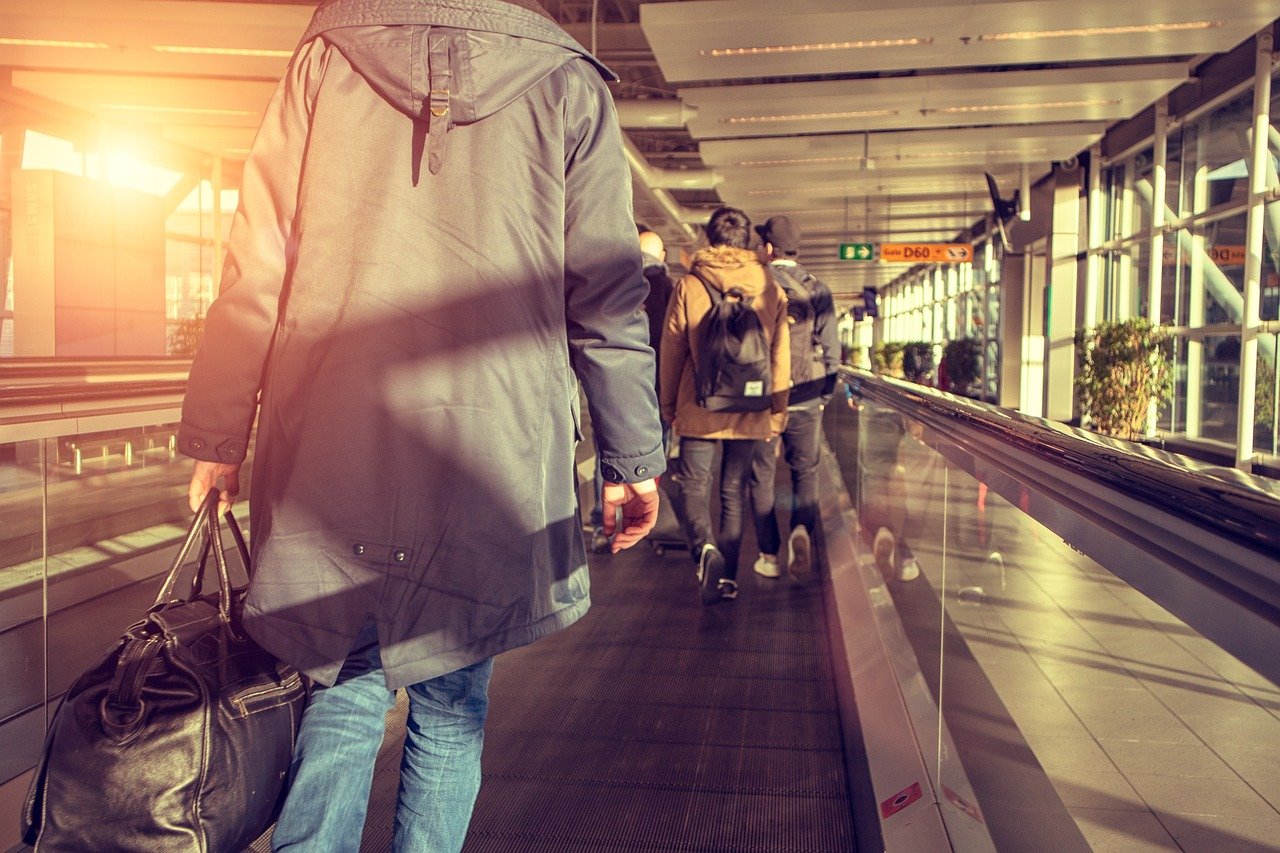 Picture of a man joining other travelers in the airport