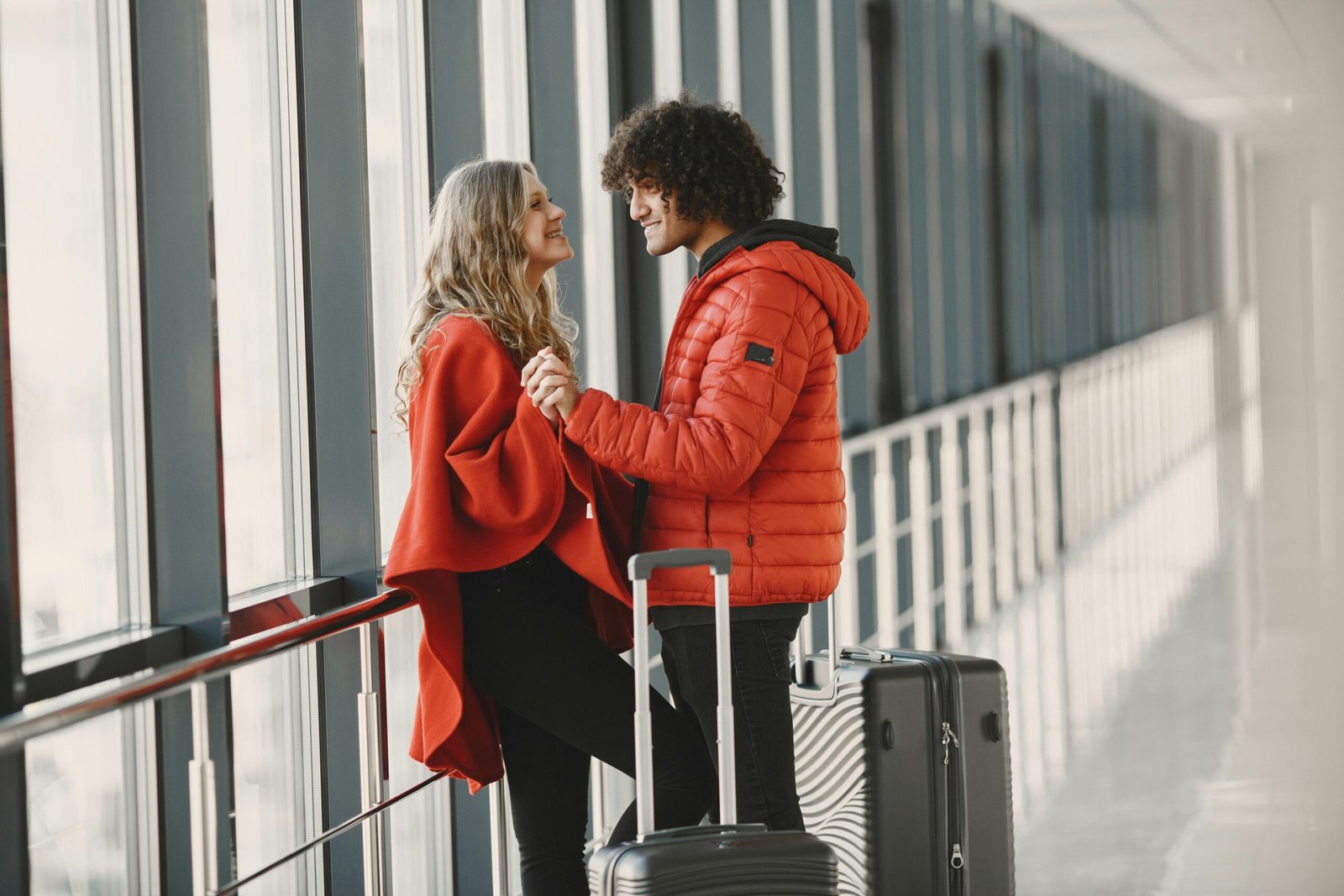 Close-up shot of a couple holding hands in an airport hallway