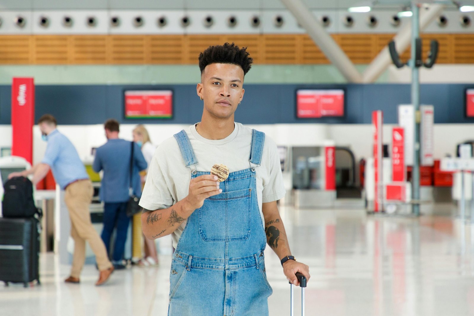 Man Wearing Denim Jumper Holding his luggage and existing the airport waiting area